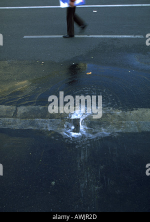 Wasserbecken auf Straße und Fußgänger, niedrige Abschnitt Stockfoto