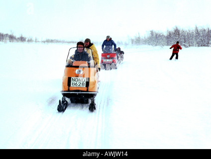 Schweden, Menschen fahren Schneemobile im Schnee Stockfoto