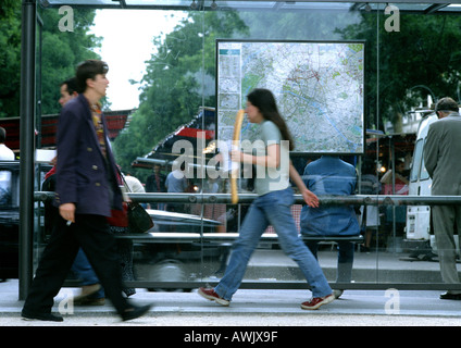 Menschen zu Fuß vorbei an Bushaltestelle, verwischt. Stockfoto