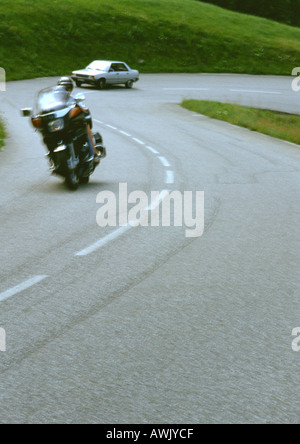 Motorrad und Auto auf kurvenreichen Straße, unscharf Stockfoto