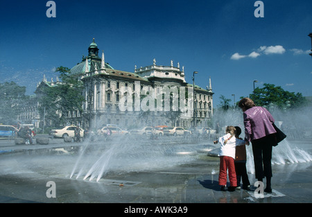 Frau mit Kindern in der Nähe von Brunnen vor dem Justizpalast, Karlsplatz, München, Bayern, Deutschland Stockfoto