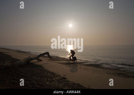 Radfahren am Strand bei Sonnenaufgang Stockfoto