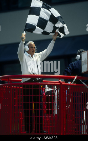 Mann, wehende Zielflagge im Motorsport Stockfoto