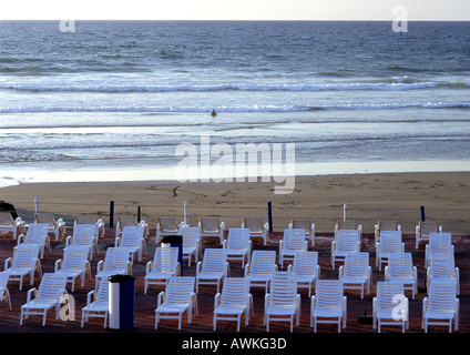 Lounge Stühle aufgereiht am Strand Stockfoto