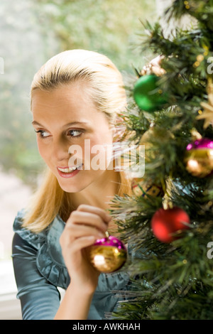 Frau schmücken den Weihnachtsbaum Stockfoto