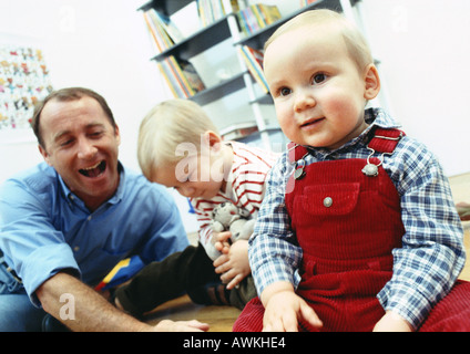 Vater auf Boden mit Söhnen innen sitzen. Stockfoto