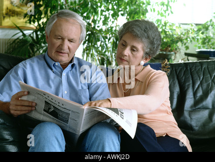 Älteres Paar auf Couch, die Zeitung lesen. Stockfoto