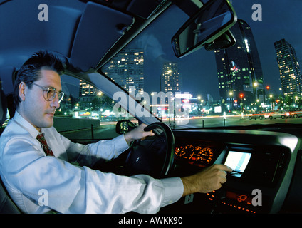 Mann im Auto in der Stadt bei Nacht Stockfoto