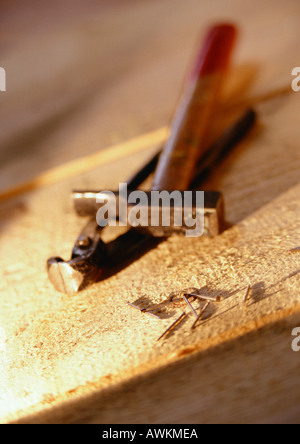 Werkzeuge und Nägel auf Holzbrett Stockfoto