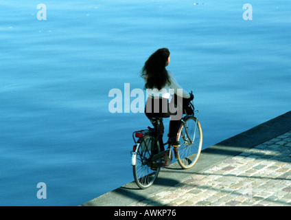 Frau Reiten Fahrrad Kanal entlang Stockfoto