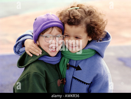 Zwei Kinder umarmen, Lächeln Stockfoto