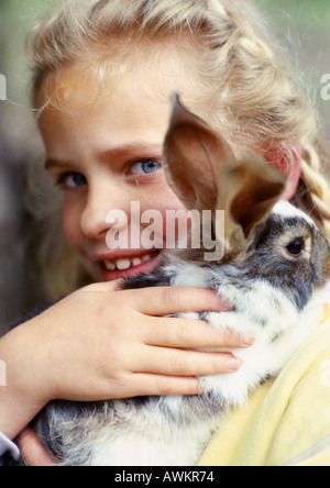 Mädchen umarmt Kaninchen, close-up Stockfoto