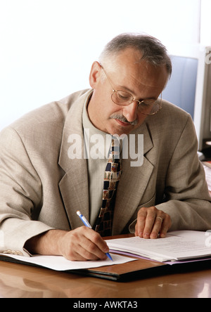 Man sitzt am Schreibtisch, schreiben Stockfoto