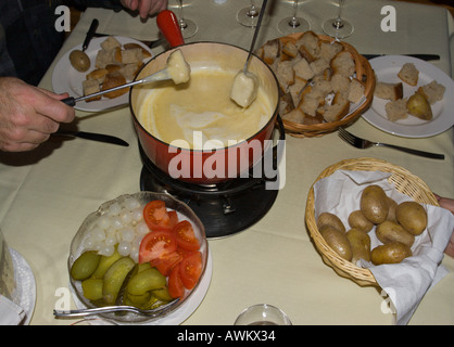 Paar Gabeln mit Stücken von Brot auf nach dem Eintauchen in geschmolzenem Käse von einem typischen traditionellen Käse Fondue Essen in der Schweiz Stockfoto