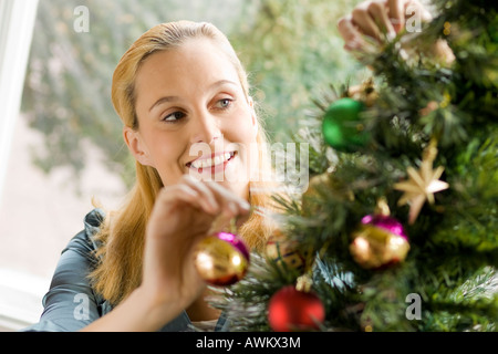 Frau schmücken den Weihnachtsbaum Stockfoto