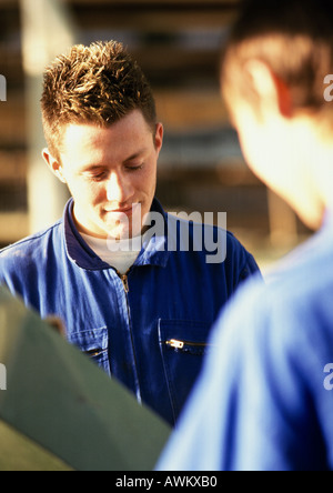 Männer in Overalls, Blick nach unten Stockfoto