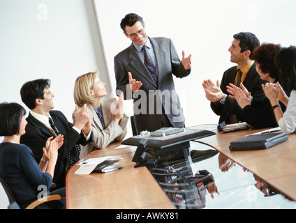 Geschäftsleute im Konferenzraum, applaudierten stehend Geschäftsmann Stockfoto