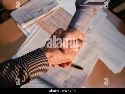Handshake über Dokumente auf Tisch Stockfoto