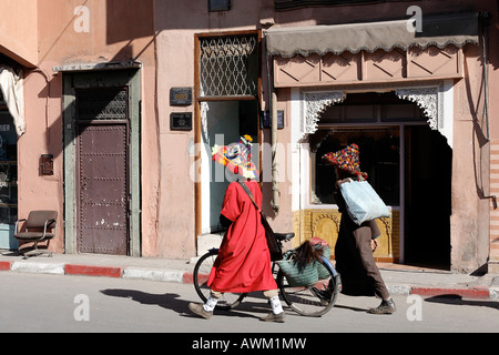 Zwei Wasserträger in traditioneller Kleidung auf ihrem Weg durch das historische Medina-Viertel, Marrakesch, Marokko, Afrika Stockfoto