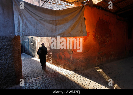 Mann zu Fuß durch eine Gasse in der Altstadt Medina von Marrakesch, Marokko, Afrika Stockfoto