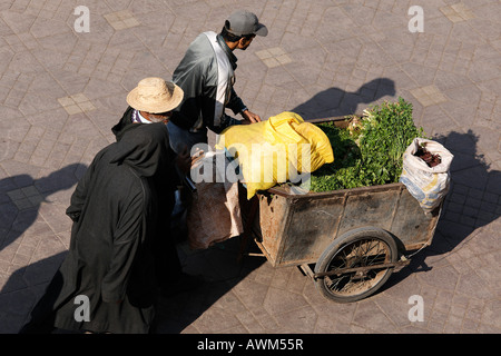 Männer Schieben Karren, beladen mit rohen grünen Gemüse und Säcke, Djemaa el Fna, Marrakesch, Marokko, Afrika Stockfoto