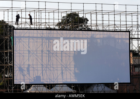 Zwei Männer installieren eine riesige Open-Air-Bildschirm, Djemaa el-Fna, Marrakesch, Marokko, Afrika Stockfoto