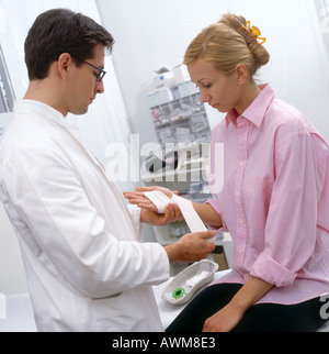 Männlichen Arzt Bandagierung Hand des Patienten Stockfoto