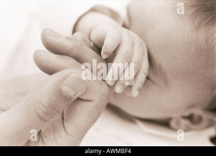 Nahaufnahme eines Mannes Hand berühren seine Babyfinger Stockfoto