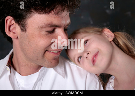 Tochter liebevoll den Kopf auf ihres Vaters Schulter ruht Stockfoto