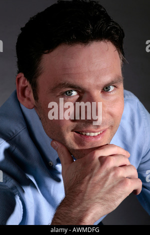 Mann trägt ein blaues Hemd ruht sein Kinn Stockfoto