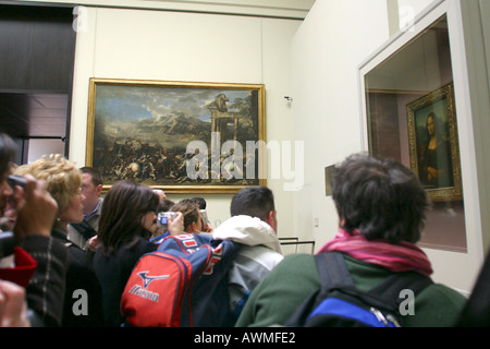 Touristen auf der Suche auf Gemälde der Mona Lisa von Leonardo da Vinci auf dem Display hinter seinen kugelsicheren Bildschirm in der Louvre-Kunst Stockfoto