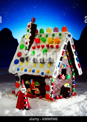 traditionelle Märchen Ingwer Brot Haus bedeckt in Süßigkeiten mit dem Weihnachtsmann Stockfoto