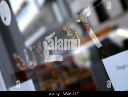 Öffnen Sie Text in Französisch, schneiden Sie Buchstaben befestigt auf Zeichenfolge im Schaufenster, Nahaufnahme Stockfoto