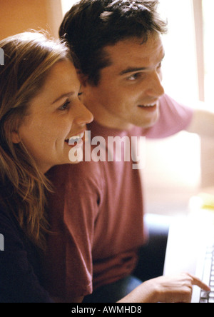 Mann und Frau nebeneinander, lächelnd, Seitenansicht Stockfoto