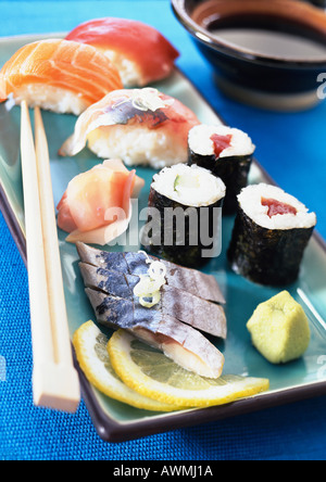 Verschiedene Arten von Sushi auf Teller mit Stäbchen, Nahaufnahme Stockfoto
