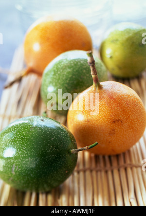 Gelbe und grüne Passionsfrucht auf Bambusmatte, Nahaufnahme Stockfoto