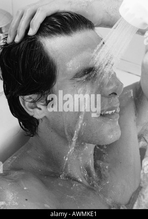 Mann in Badewanne, Spülen Gesicht, b&w Stockfoto