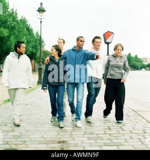 Sechs junge Leute zusammen auf Kopfsteinpflaster gehen Stockfoto