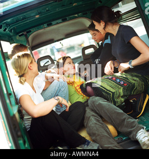 Gruppe von Jugendlichen sitzen hinter van Stockfoto