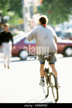 Person Reiten Fahrrad in Straße, Rückansicht Stockfoto