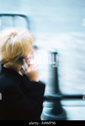 Frau mit Handy in der Straße, unscharf Stockfoto