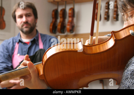 Geigenbauer (Geigenbauer) mit einem Kunden in seinem Geschäft Stockfoto