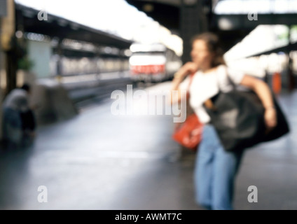 Frau zu Fuß mit Tasche in Nähe des Bahnhofs, verwischt. Stockfoto