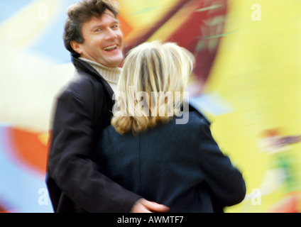 Mann und Frau Rückansicht zusammen, Mann auf der Suche über die Schulter mit Arm um Frau, unscharf Stockfoto
