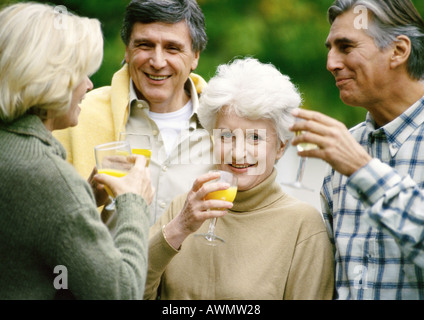 Ältere Menschen stehen zusammen mit Drinks in Händen, Nahaufnahme Stockfoto