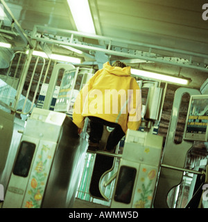 Junger Mann springen über Drehkreuz in u-Bahn Stockfoto