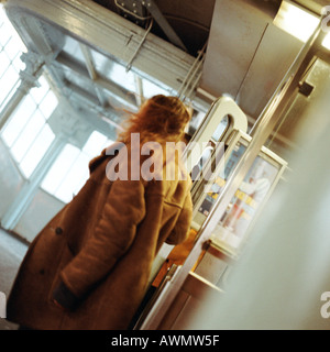 Junge Frau, die zu Fuß durch Türen in die u-Bahnstation Stockfoto