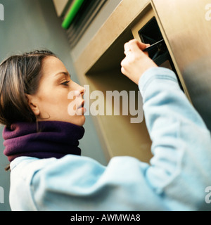 Junge Frau am ATM Maschine, Kopf und Schultern, close-up Stockfoto