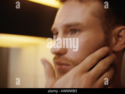 Mann berühren Gesicht, Seitenansicht, Nahaufnahme, verwischt. Stockfoto