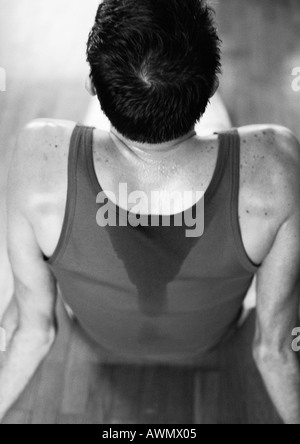 Mann sitzt am Boden, tragen verschwitzt Tanktop, erhöhte hintere Ansicht, schwarz und weiß. Stockfoto